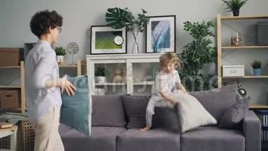 一个年轻的女人和一个小孩在沙发上扔垫子，玩枕头大战